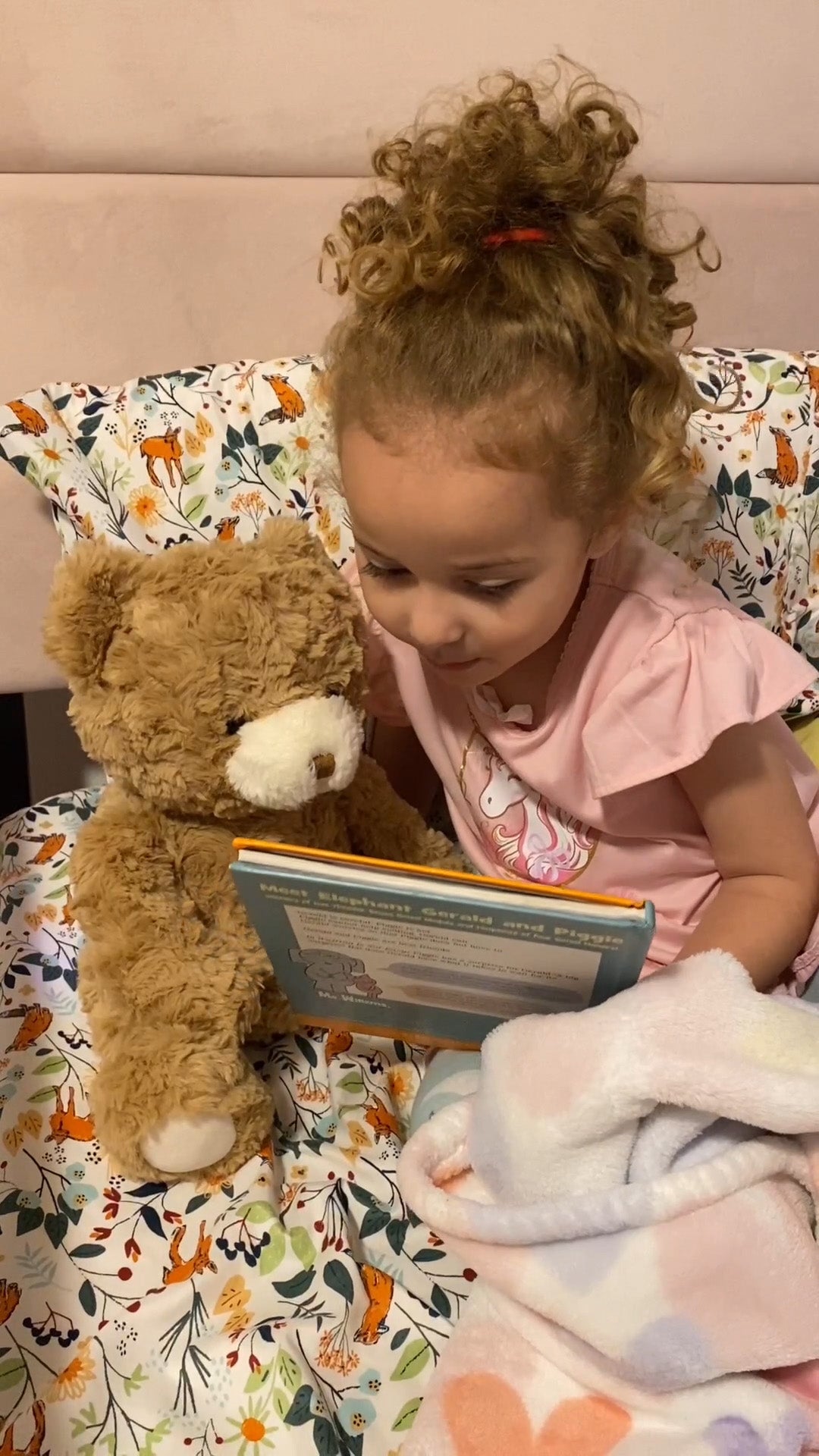 A girl is listening to Ebloma ai bear tell a story.